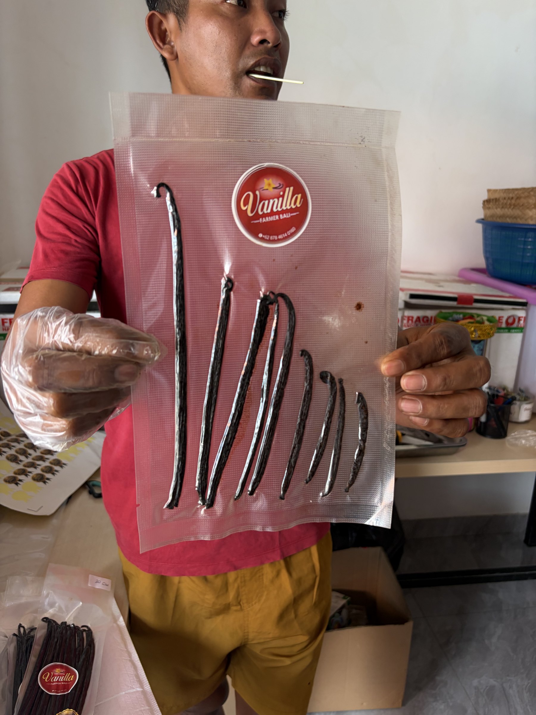 Gustu holding a bag of vanilla beans sorted from long to short