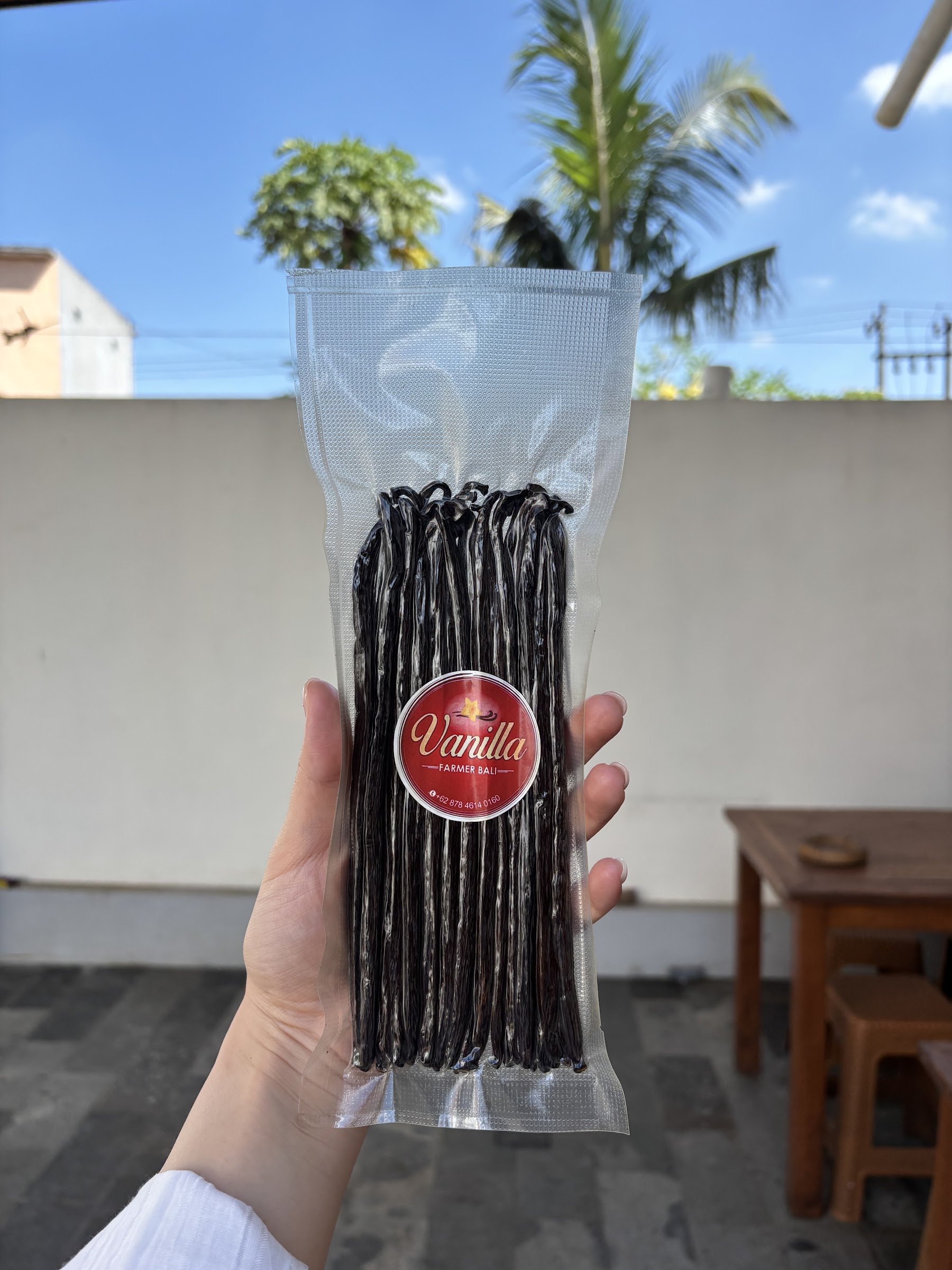 A sealed bag of long vanilla beans with the red Vanilla Farmer Bali sticker