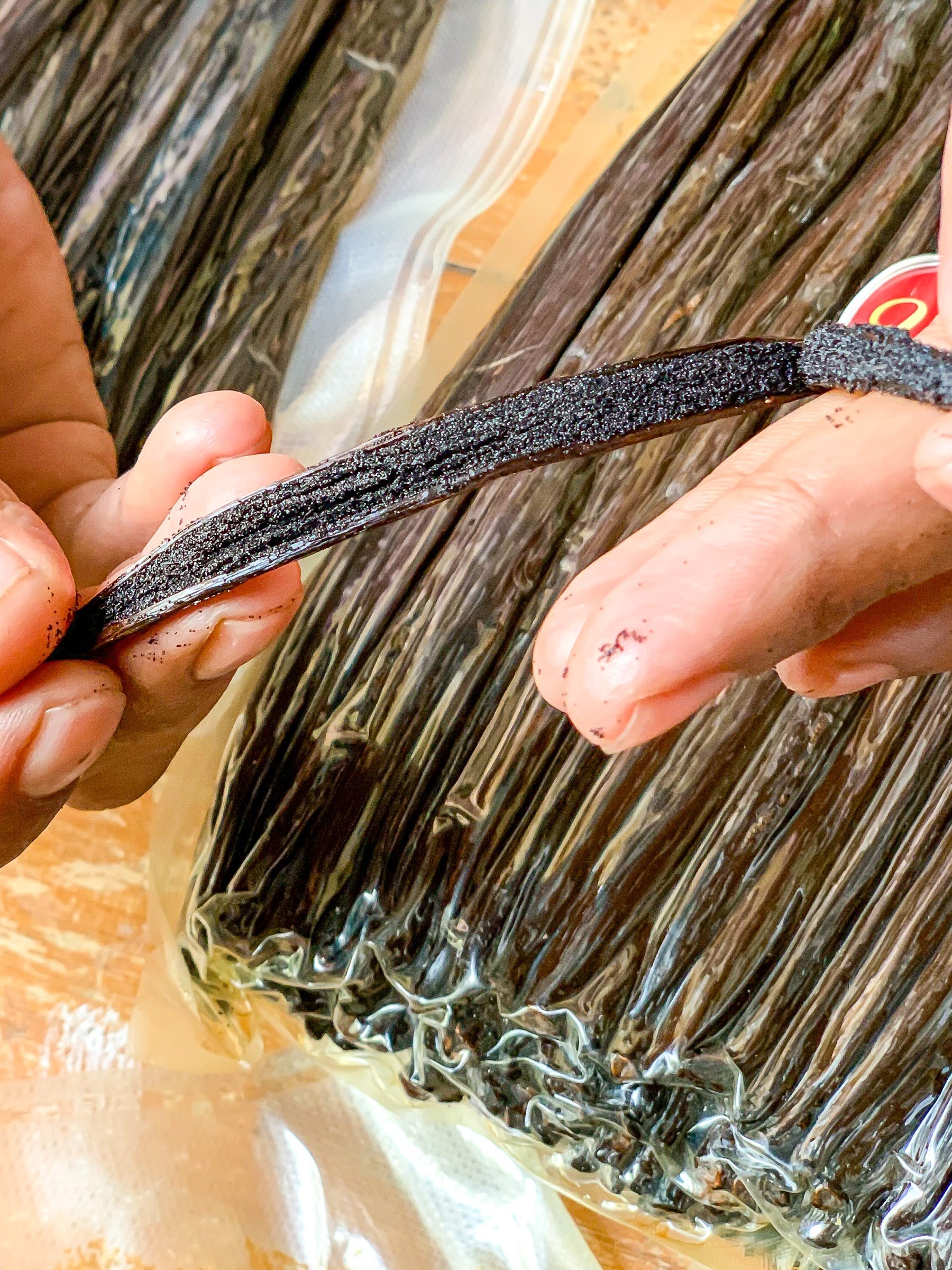 A cured vanilla bean split open, showing the seeds